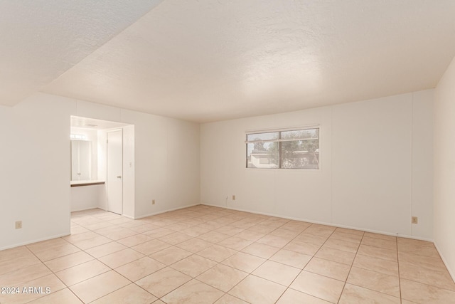 8027 N 32nd Ave, Phoenix, AZ 85051 - unfurnished room with light tile patterned flooring, a textured ceiling, and baseboards