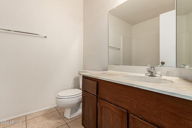 bathroom featuring walk in shower, tile patterned flooring, vanity, and toilet