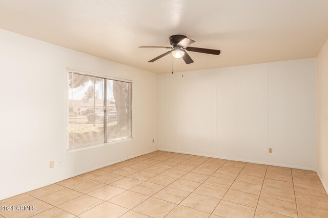 spare room with ceiling fan and light tile patterned flooring