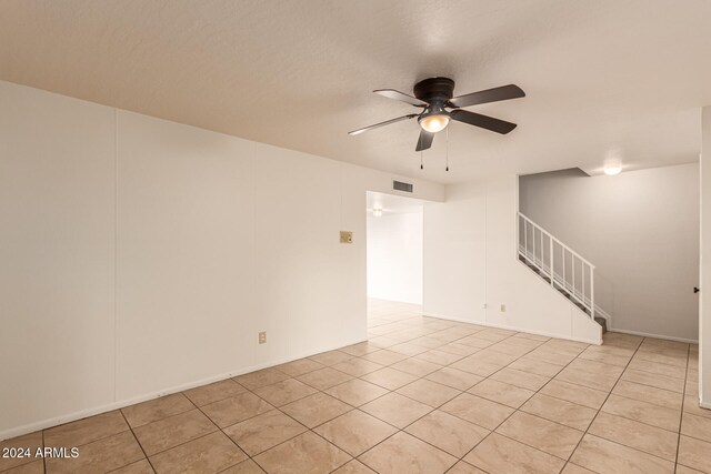 tiled spare room with ceiling fan