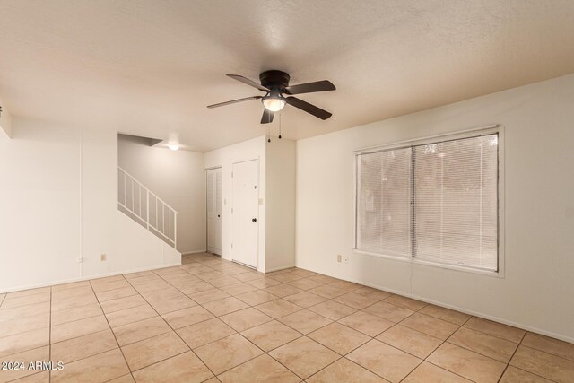 8027 N 32nd Ave, Phoenix, AZ 85051 - unfurnished room featuring stairway, ceiling fan, light tile patterned flooring, and baseboards