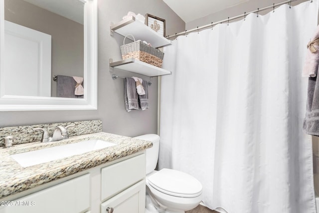 bathroom with vanity, toilet, and vaulted ceiling