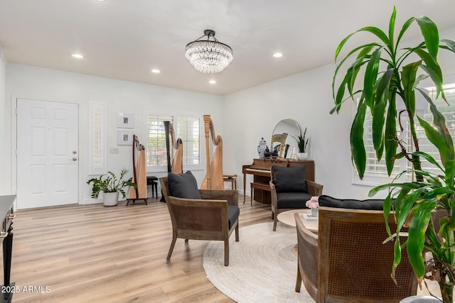 living area with light hardwood / wood-style floors and a notable chandelier