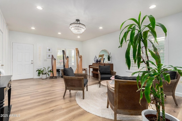 sitting room featuring light wood-type flooring and a chandelier