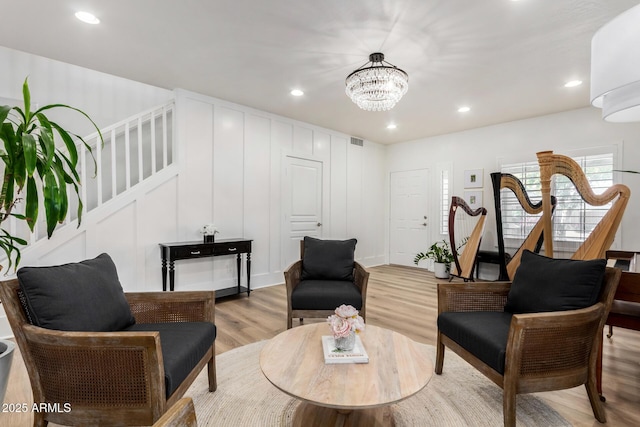 living room featuring a chandelier and light hardwood / wood-style flooring