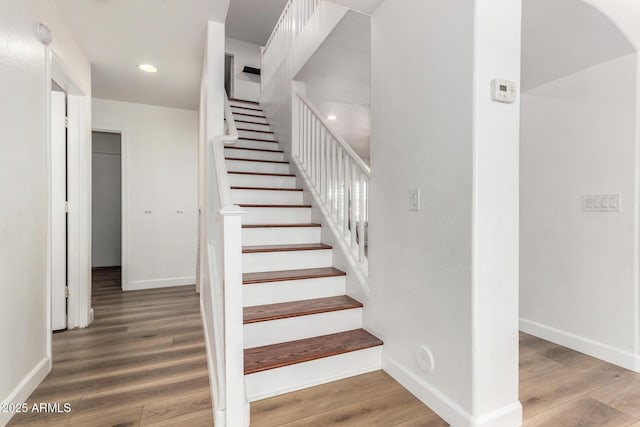 staircase with hardwood / wood-style flooring