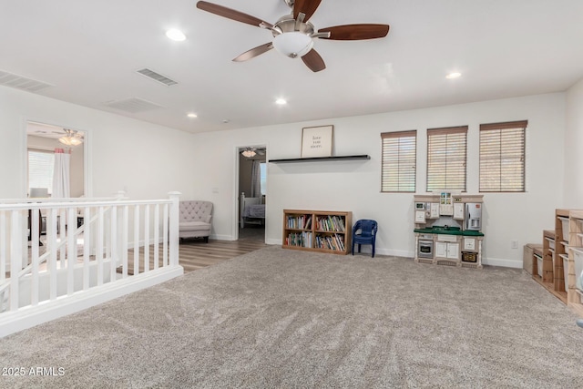 miscellaneous room with ceiling fan and light colored carpet