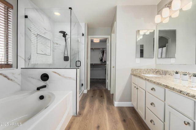 bathroom with hardwood / wood-style floors, vanity, and separate shower and tub