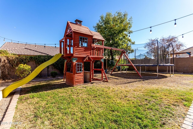 view of jungle gym with a lawn and a trampoline