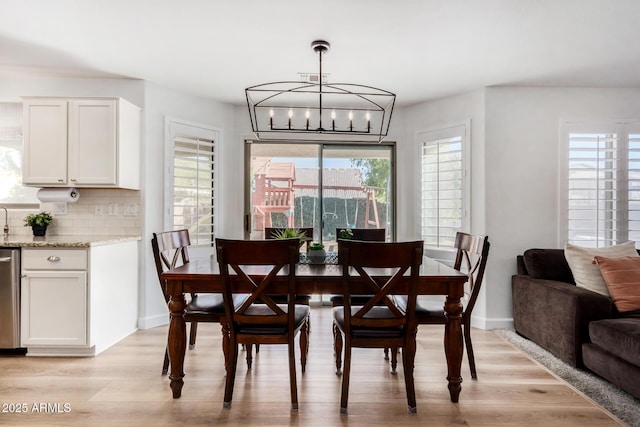 dining space featuring a notable chandelier and light hardwood / wood-style floors