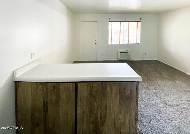 kitchen with dark colored carpet and a wall mounted AC