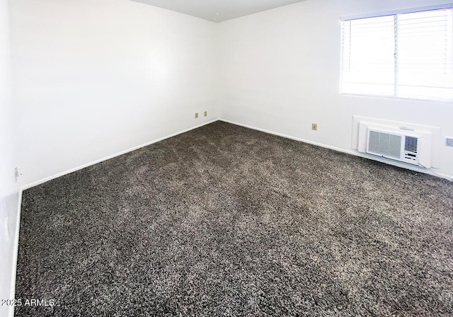 spare room featuring a wall mounted air conditioner and carpet floors