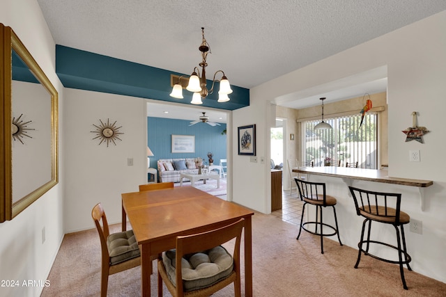 dining room with a textured ceiling, ceiling fan with notable chandelier, and light carpet