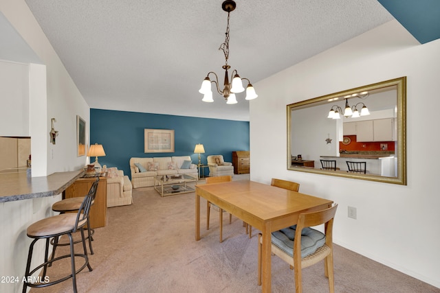 dining area featuring carpet floors, a textured ceiling, and an inviting chandelier