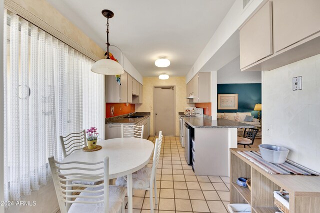 kitchen featuring range with electric cooktop, stainless steel dishwasher, sink, pendant lighting, and light tile patterned floors