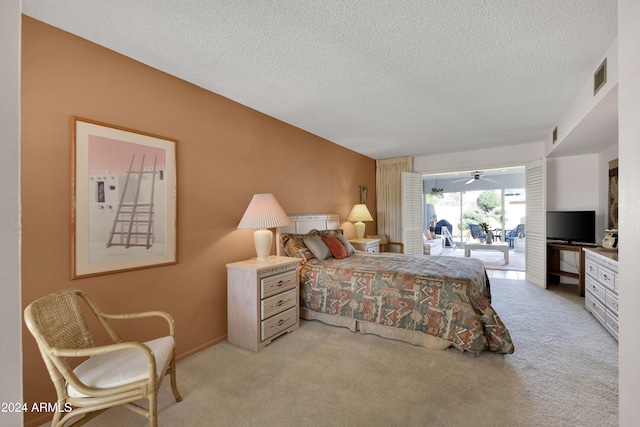 carpeted bedroom with access to outside and a textured ceiling