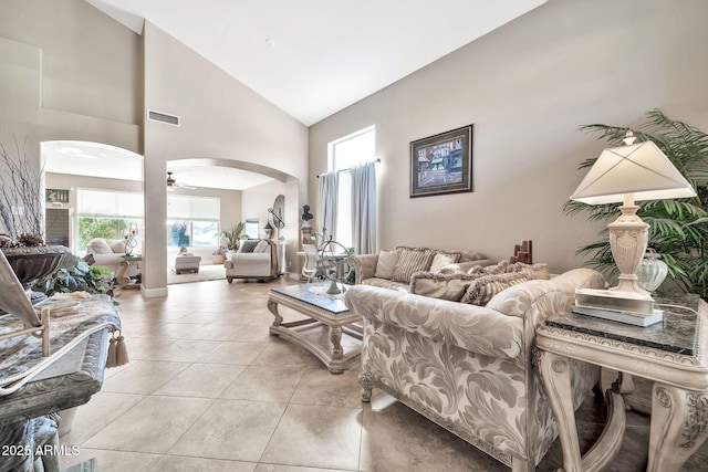 tiled living room featuring high vaulted ceiling and ceiling fan