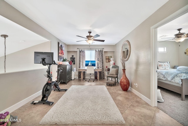 workout room with light tile patterned floors and ceiling fan