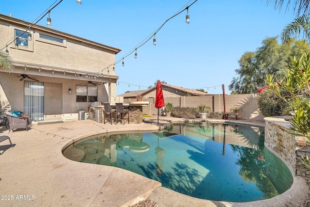 view of pool with ceiling fan, exterior bar, and a patio