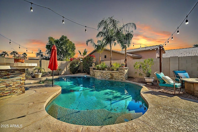 pool at dusk featuring a patio