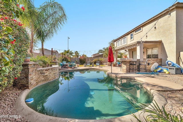 view of swimming pool featuring a bar and a patio