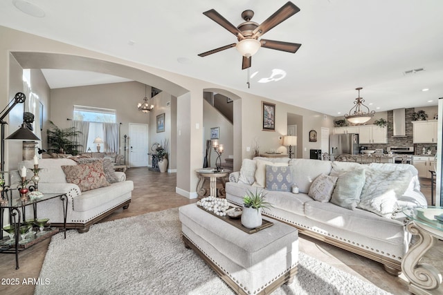 living room featuring vaulted ceiling and ceiling fan with notable chandelier