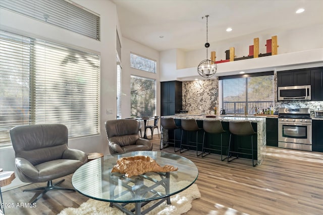 interior space featuring a high ceiling, light hardwood / wood-style floors, and a notable chandelier