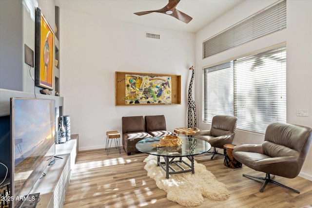 living area with ceiling fan and light wood-type flooring