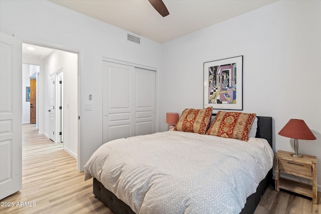 bedroom with hardwood / wood-style floors, ceiling fan, and a closet