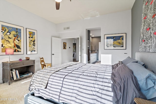 carpeted bedroom with ceiling fan and ensuite bath