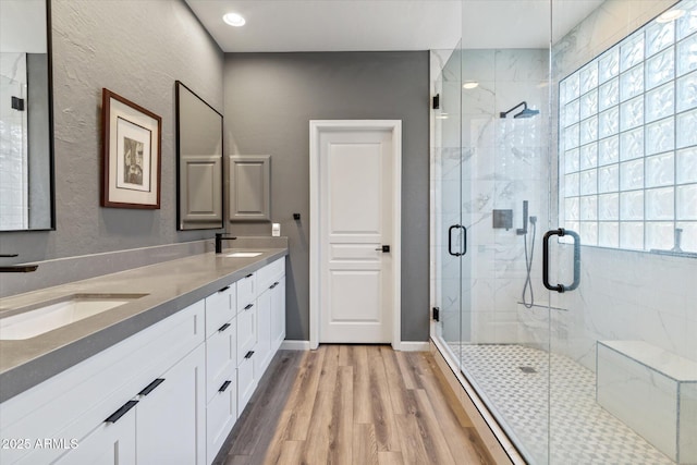 bathroom with hardwood / wood-style flooring, vanity, and a shower with shower door