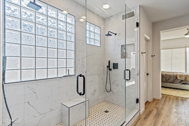 bathroom featuring a shower with shower door and hardwood / wood-style flooring