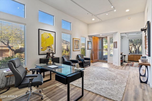 home office featuring rail lighting and light hardwood / wood-style floors