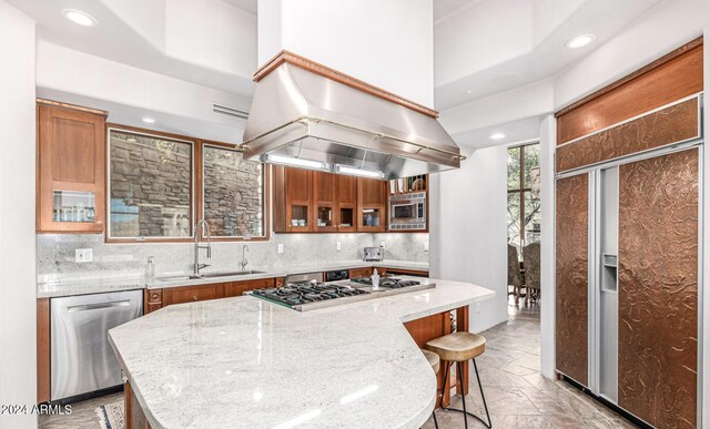 kitchen featuring tasteful backsplash, sink, stainless steel appliances, and a kitchen island