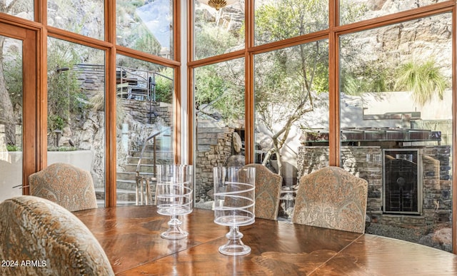 dining room with floor to ceiling windows and a stone fireplace