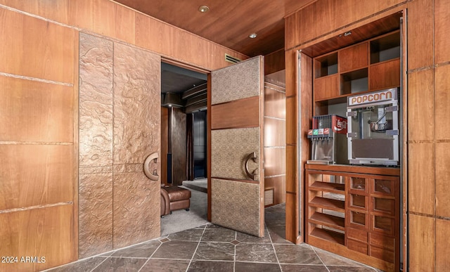 interior space featuring wooden ceiling, visible vents, and stone finish floor