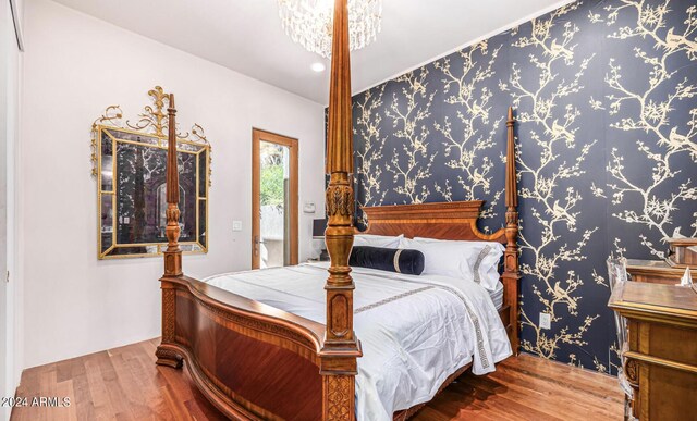 bedroom featuring hardwood / wood-style flooring and an inviting chandelier