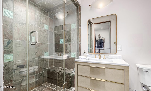 bathroom with vanity, toilet, and a shower stall