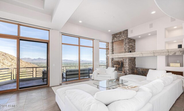 tiled living room featuring a stone fireplace and a mountain view