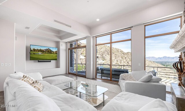 living room featuring a mountain view, hardwood / wood-style floors, and a tray ceiling