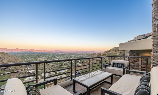 balcony at dusk featuring an outdoor hangout area