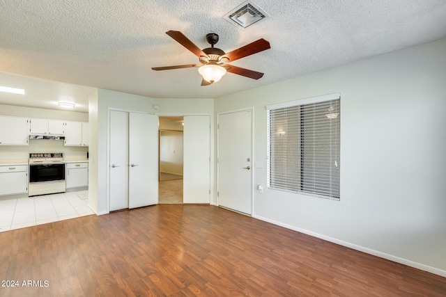 14300 W Bell Rd Unit 35, Surprise, AZ 85374 - unfurnished living room with a textured ceiling, visible vents, light wood-style flooring, and a ceiling fan