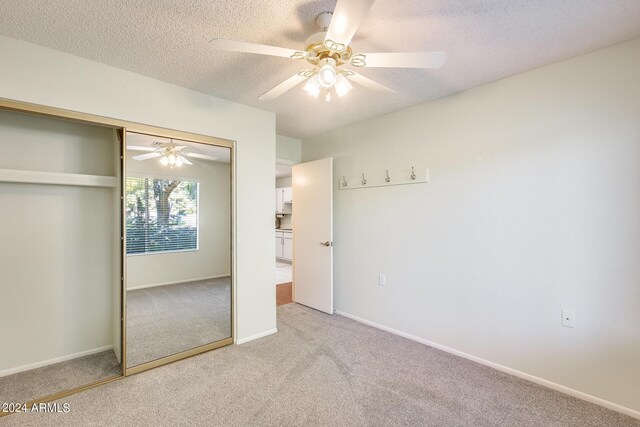 14300 W Bell Rd Unit 35, Surprise, AZ 85374 - unfurnished bedroom with a closet, light carpet, a textured ceiling, baseboards, and ceiling fan