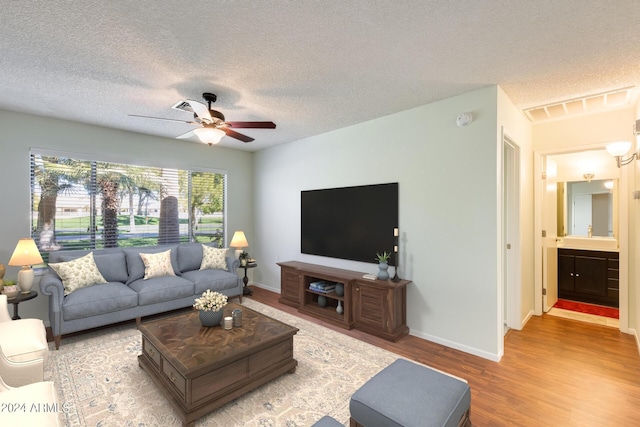 14300 W Bell Rd Unit 35, Surprise, AZ 85374 - living room featuring a textured ceiling, visible vents, baseboards, ceiling fan, and light wood-style floors