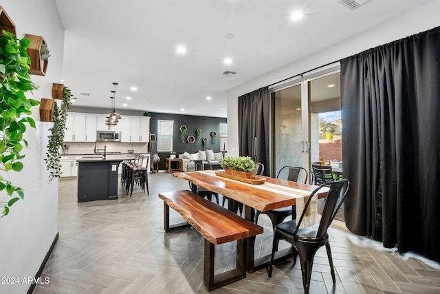 dining area with light parquet floors and sink