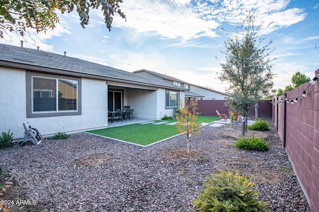 rear view of house featuring a patio area and a yard