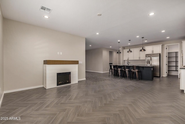 unfurnished living room featuring dark parquet floors and sink