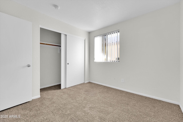 unfurnished bedroom featuring carpet and a closet