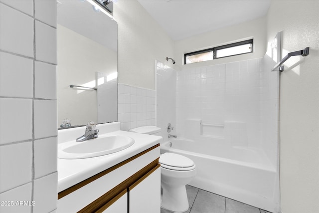 full bathroom featuring tile patterned floors, tile walls, toilet, vanity, and shower / bathtub combination