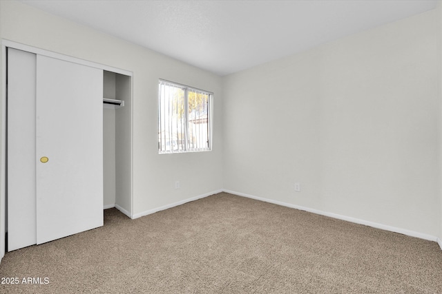 unfurnished bedroom featuring carpet and a closet